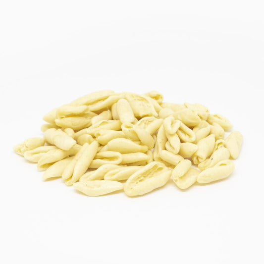 Pile of uncooked pasta cavatelli on a white background