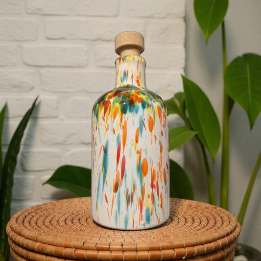 Colourful ceramic bottle with a cork on a wicker table, plants and white stone wall background
