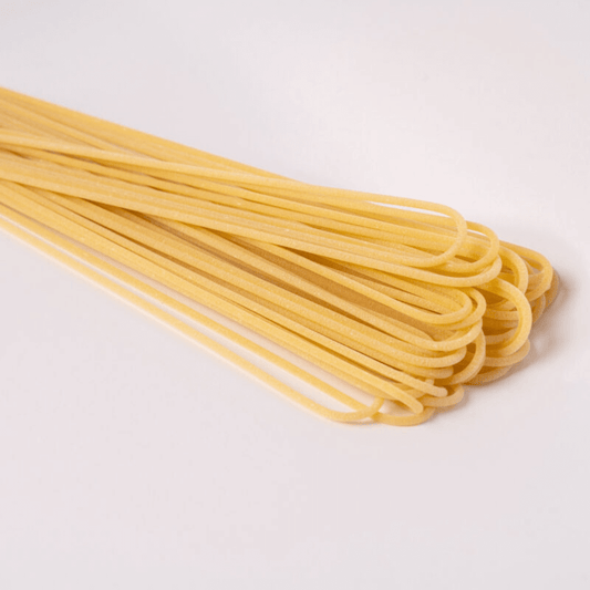 uncooked pasta spaghetti on a white background