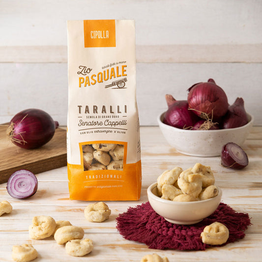 Zio Pasquale Taralli package with fresh red onions on a wooden surface.