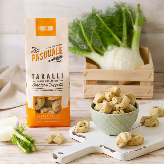 A packet of Taralli with fresh fennel on a wooden table