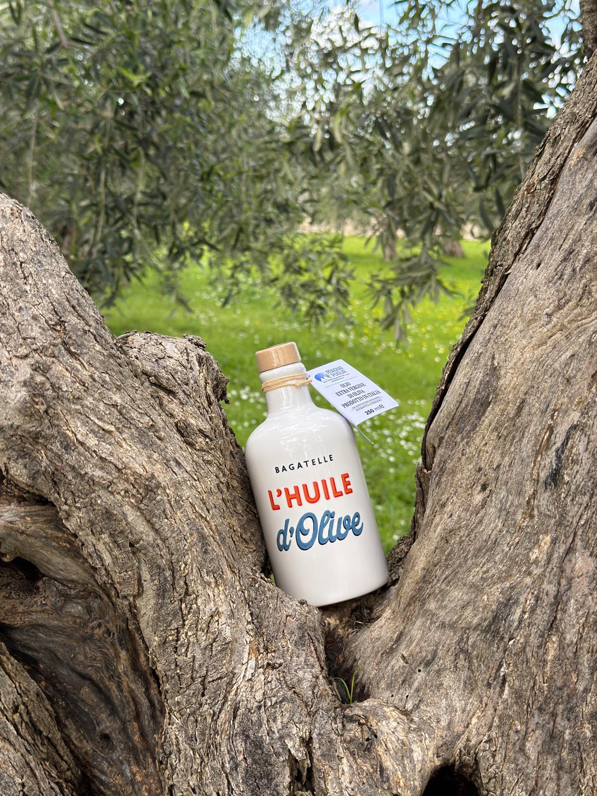 Bottle of 'L'Huile d'Olive' surrounded by olive trees
