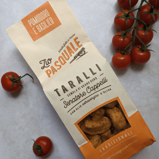 taralli tomato & basil on a light surface with fresh tomatoes on the vine