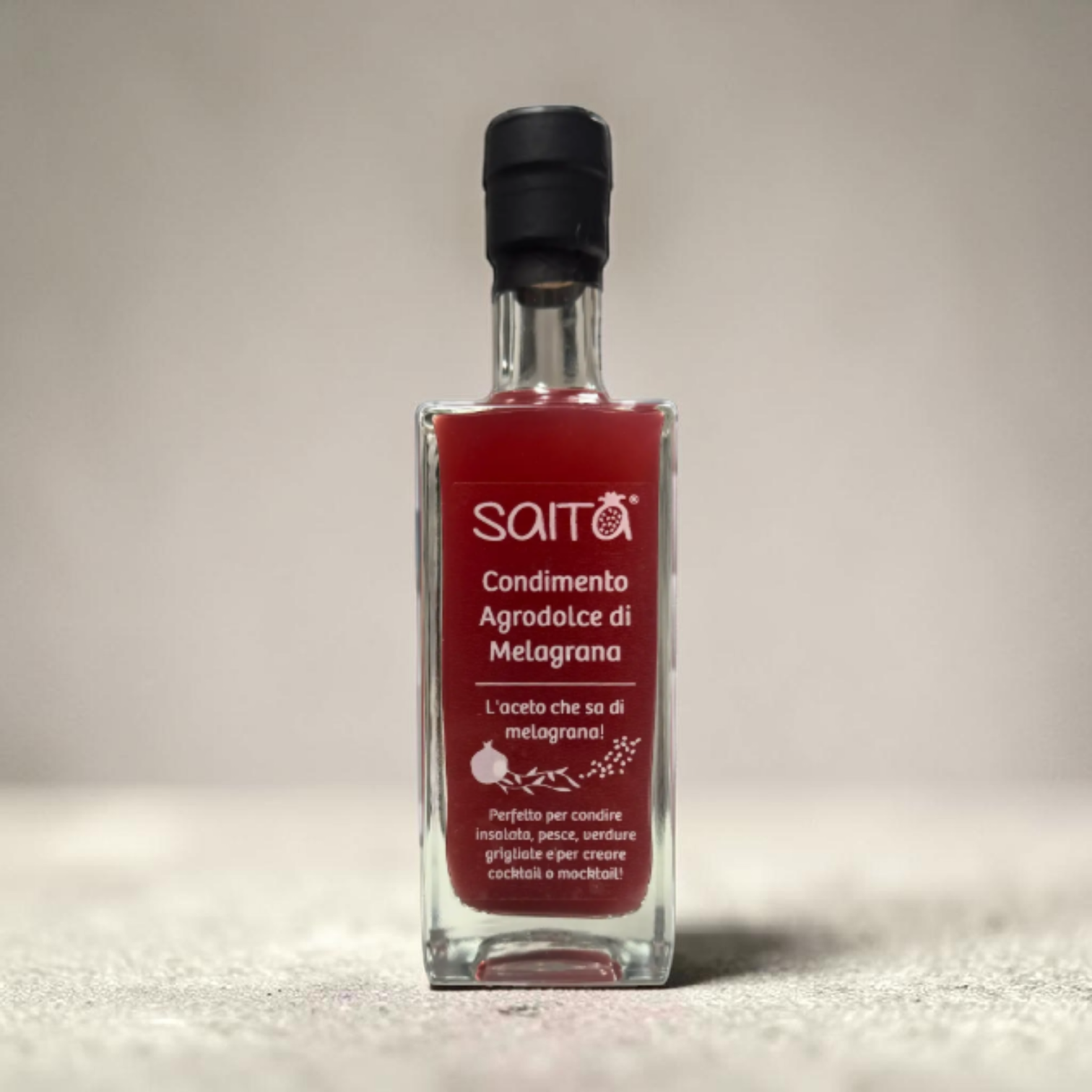 Bottle of Saita agrodolce di melagrana on a neutral background