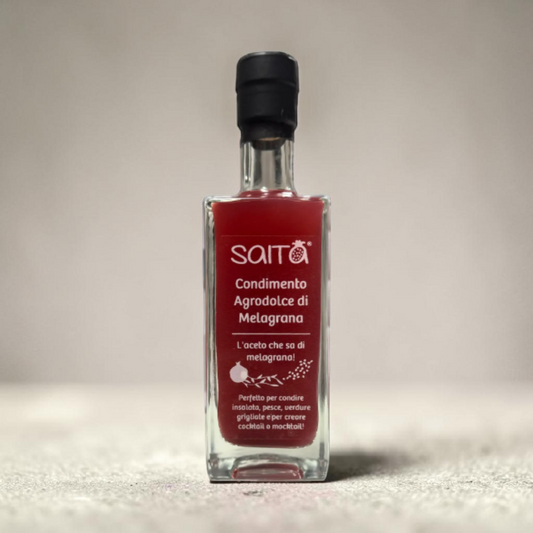 Bottle of Saita agrodolce di melagrana on a neutral background