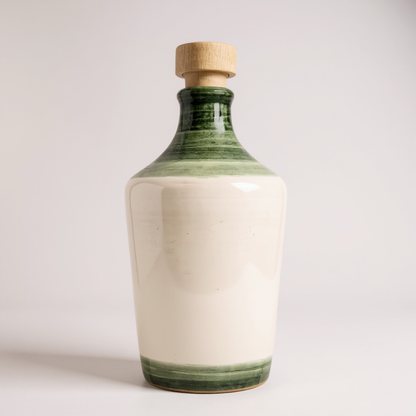 ceramic bottle decorated in white and green in a white background