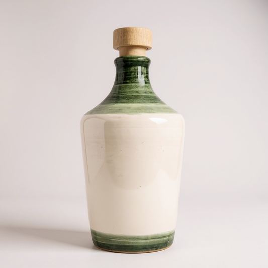 ceramic bottle decorated in white and green in a white background