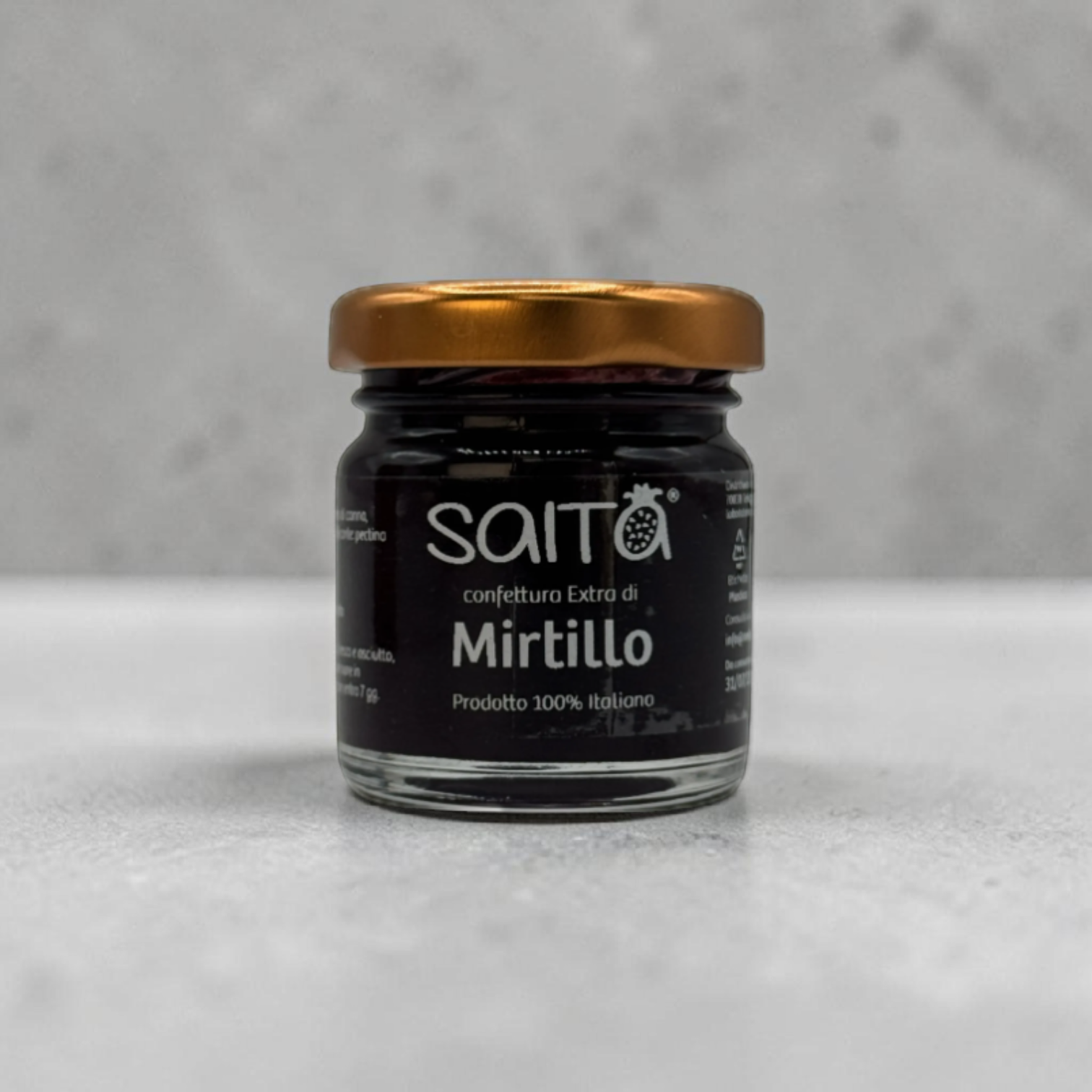 Jar of Saito Mirtillo jam with a gold lid on a gray background