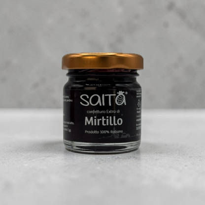 Jar of Saito Mirtillo jam with a gold lid on a gray background