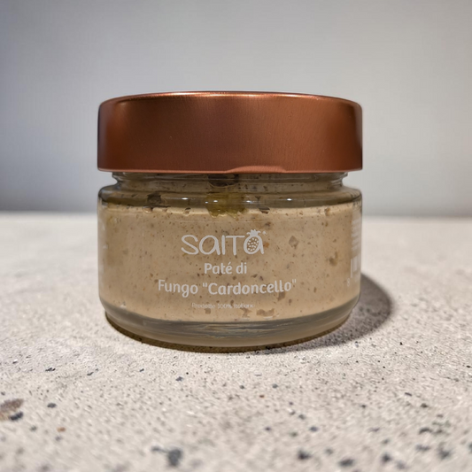 Jar of mushroom pate with a brown lid on a grey surface