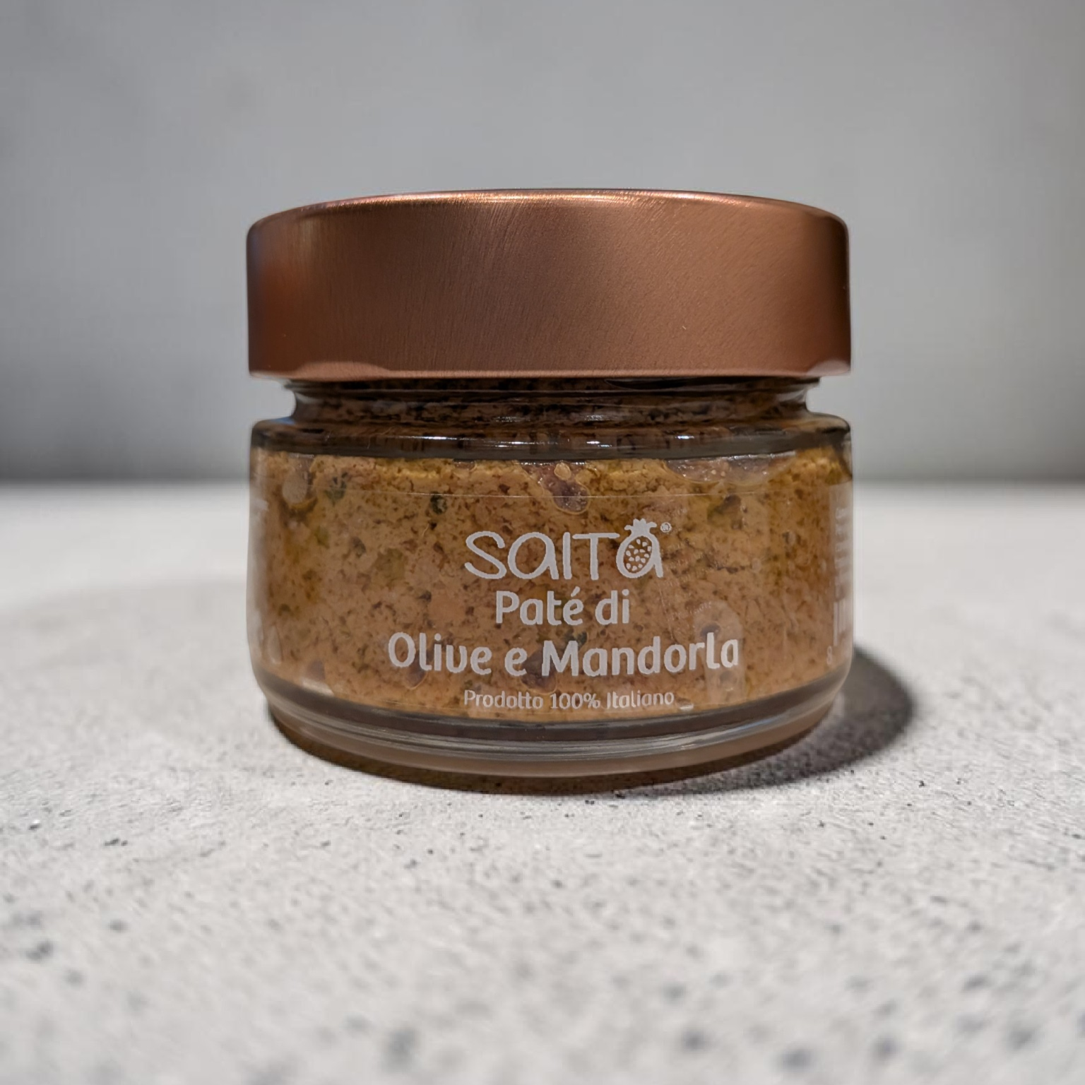 Jar of Saitá olive and almond paste on a grey background