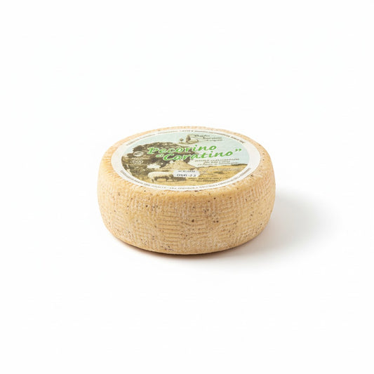 Round sheep's milk cheese wheel with a label on a white background