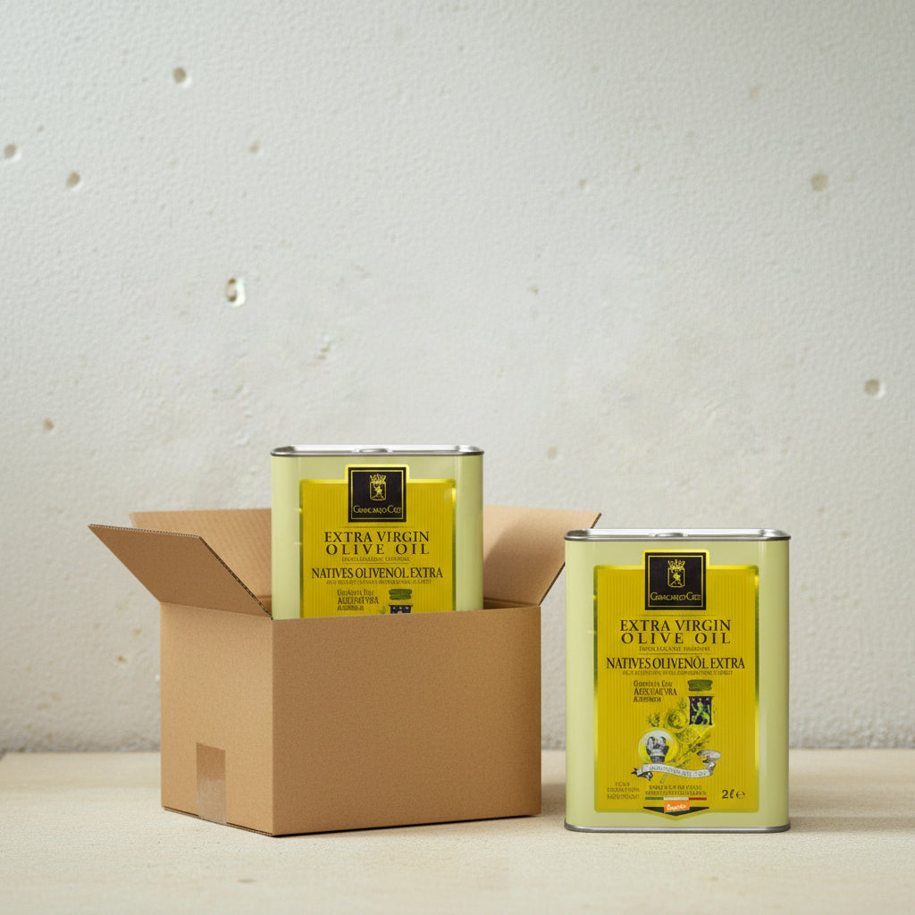 two tins of 2l organic olive oil, one is in a cardboard box and the other one next to it, simple beige surface and light grey concrete wall behind