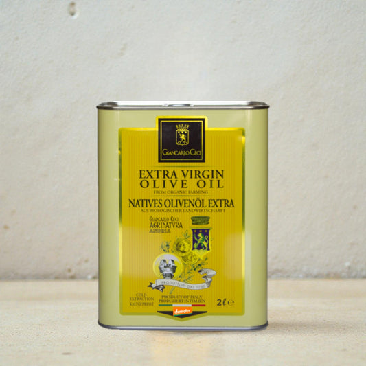 a tin of olive oil on a beige surface with a white plaster wall in the background