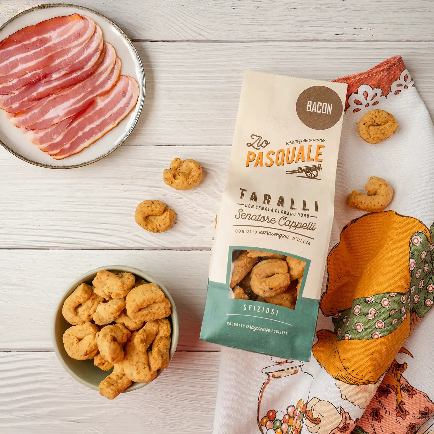 Taralli snacks with a package labeled 'Zio Pasquale' on a wooden surface.