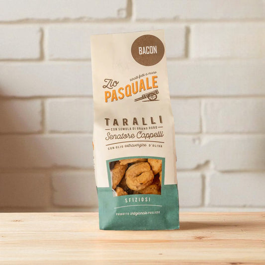 Zio Pasquale Taralli snack package on a wooden surface with a white tiled wall background
