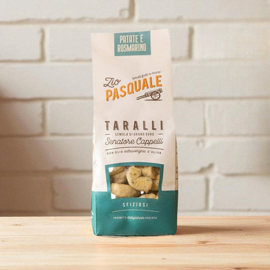 Package of Zio Pasquale Taralli on a wooden surface with a stone wall background