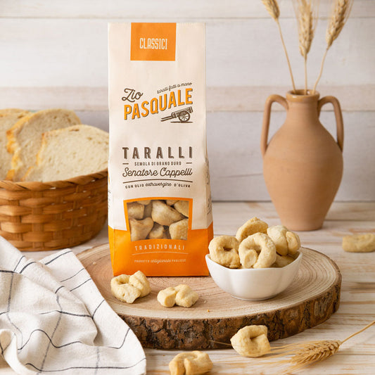 Zio Pasquale Taralli  snack package on a wooden board with snacks and bread in the background.